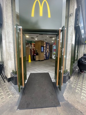 Green wooden doors with glass panels ahead. Brown vertical handles to centre. Pull to open.