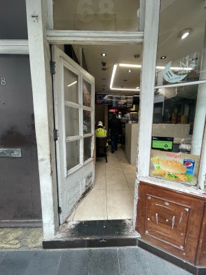 Glass door with white frame ahead. Gold handle to right. Push to open.