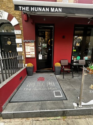 Entrance door ahead after one step followed by rug. Black door with golden handle on mid right after second small step. Push to open.