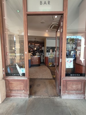 Brown framed glass door. Push silver handle on left to open.