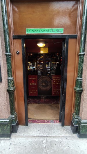 From sidewalk facing venue. Path ahead with a bump before door.