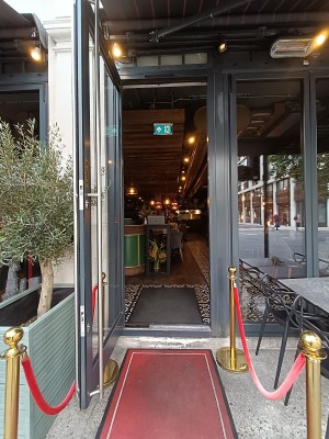 Glass door with grey frame. Metal silver vertical handle on right. Pull to open.