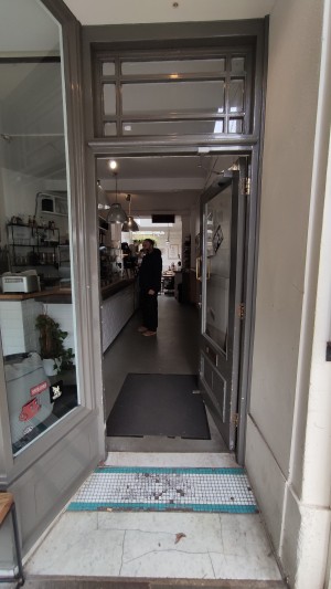 From sidewalk facing venue. Built in ramp ahead to door.