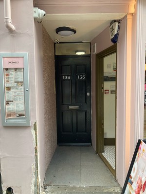 Access to venue via open archway. Path ahead. Door to venue right.