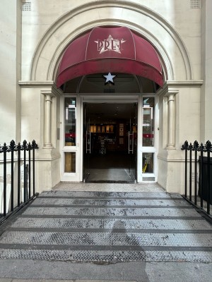 Walkway with built in ramp up to double glass doors ahead.