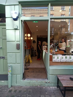 Glass door with black, metal vertical handle along right. Push to open.