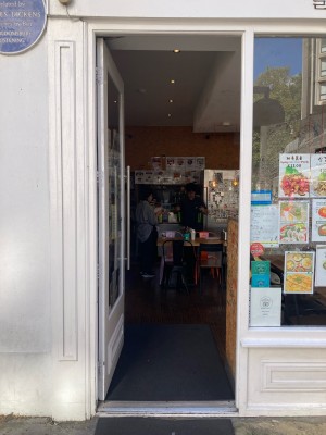 Access via glass door with white frame. Push open via vertical metal handrail on right.