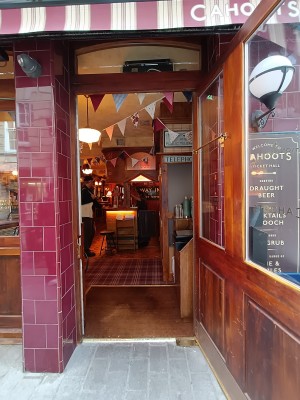 Glass door with brown wooden frame. Grey handle on left. Pull to open.