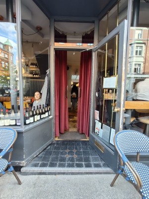 Facing entrance. Grey framed single glass door ahead. Pull golden metal doorknob on left to open.