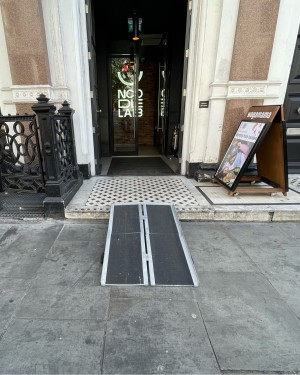 Path ahead to first set of entrance doors. One step up before door. Ramp on request from pavement to step.