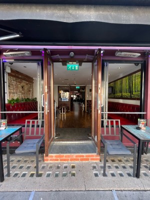 Double glass doors in brown wooden frame. Pull silver metal handles from centre to open.