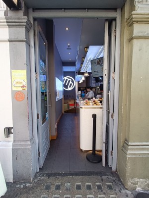 Glass doors with grey frame. Silver, metal vertical handles in the middle. Push to open.