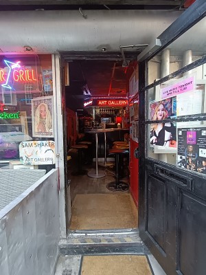 Glass door with black frame. Black, metal vertical handle on left. Pull to open.