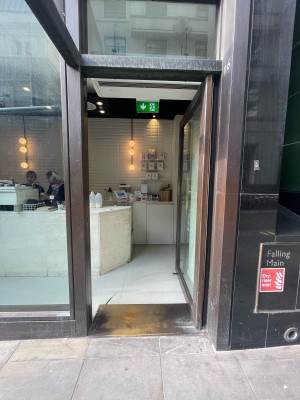 Glass door with dark brown frame ahead. Push to open.