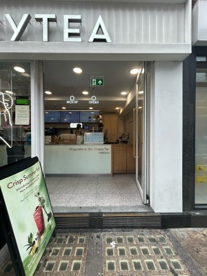 Double glass doors with white frame and gold metal vertical handles in middle. Push to open. Counter beyond. A-frame on left.