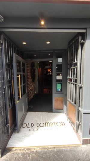 From sidewalk facing venue. Grey gates ahead. Push in centre to open. Built in ramp at foot of gates.