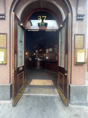 Glass doors with brown frame. Golden metal handle in middle. Pull to open.