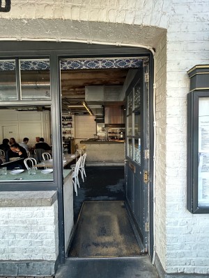 Single grey wooden door with glass panels. Push gold handle on left to open.