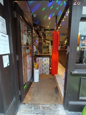 Glass door with brown frame. Golden, metal handle on right. Push to open.