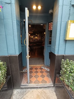 Glass door with blue frame. Golden, metal handle on right. Pull to open.