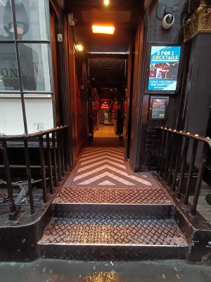 From sidewalk facing venue. Two steps up to entrance.