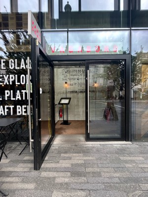 Double glass doors with black frame and silver metal vertical handles in middle. Pull to open.