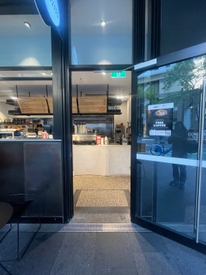 Glass door with black metal frame. Pull from left to open.