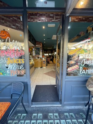 Grey wooden and glass door ahead. Gold vertical metal handle to left. Push to open.