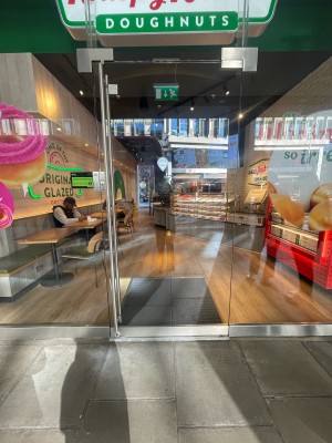 Glass door ahead. Silver vertical metal handle to left. Push to open.