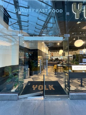 Double glass doors in glass frame. Push vertical metal handles from centre to open.