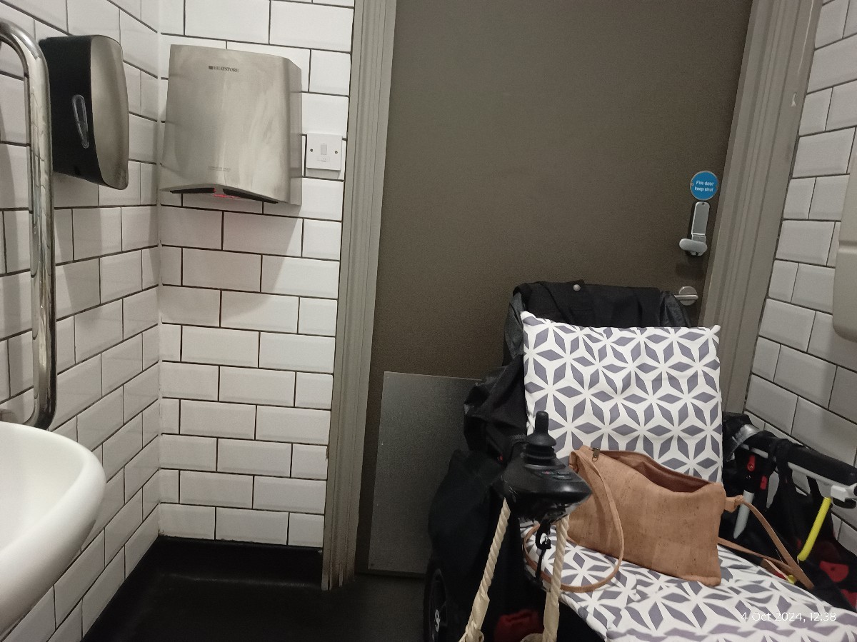 This photo shows the height of the hand dryer and sink in comparison with my chair.