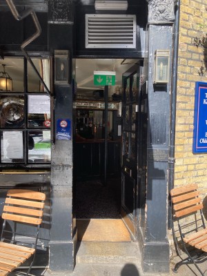 Single black wooden door with glass panels. Push to open via metal pad on the left.
