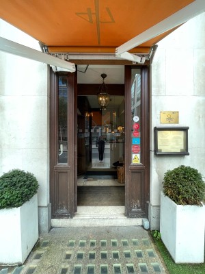 Brown wood and glass door. Push on right  of door to open.