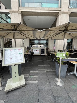 Open archway through outdoor front area. Path ahead turns right at reception desk.