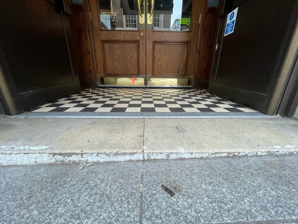 Small step before door. Metal bump along centre of door.