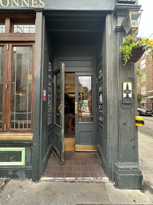 Opening followed by grey and glass panelled doors. Gold metal handles in centre, pull to open.