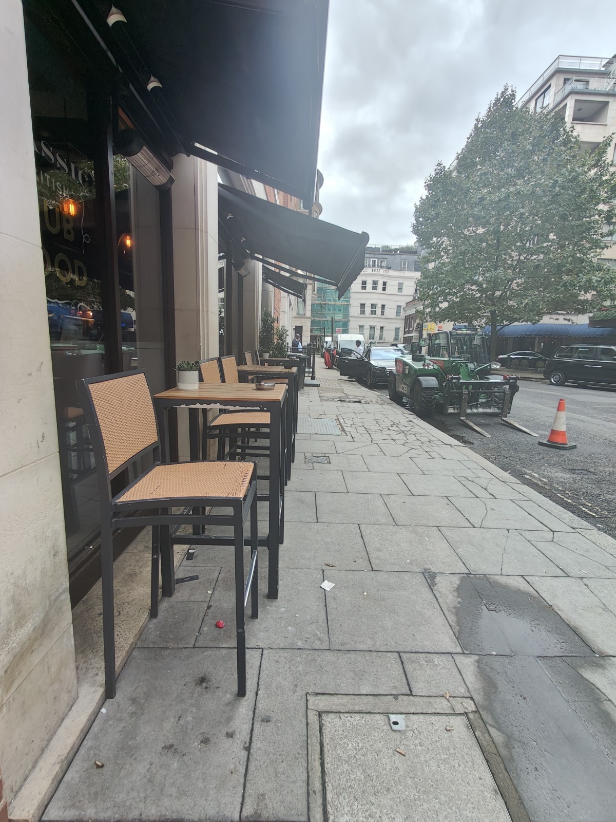From after second A-board facing straight. High tables and stools along left glass wall. Straight path on right.