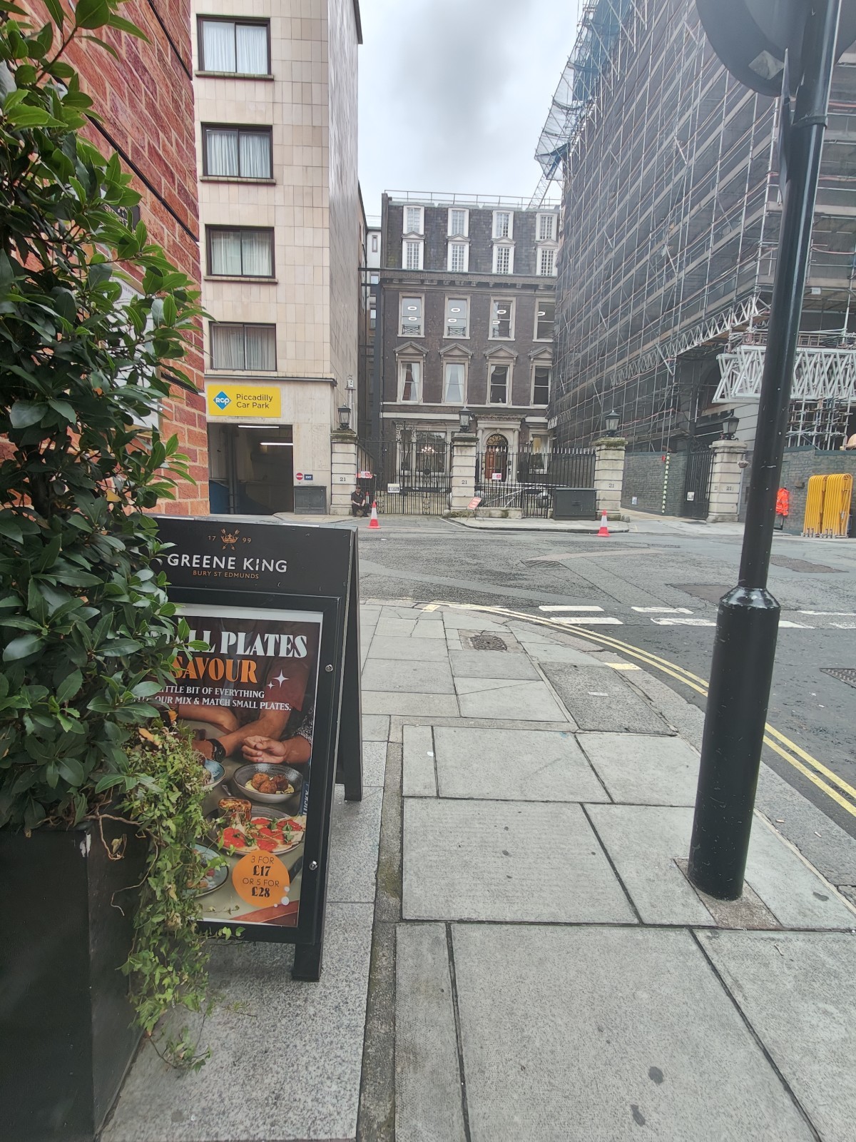 From outside entrance facing right. A-board on left. Path ahead going left to seating.