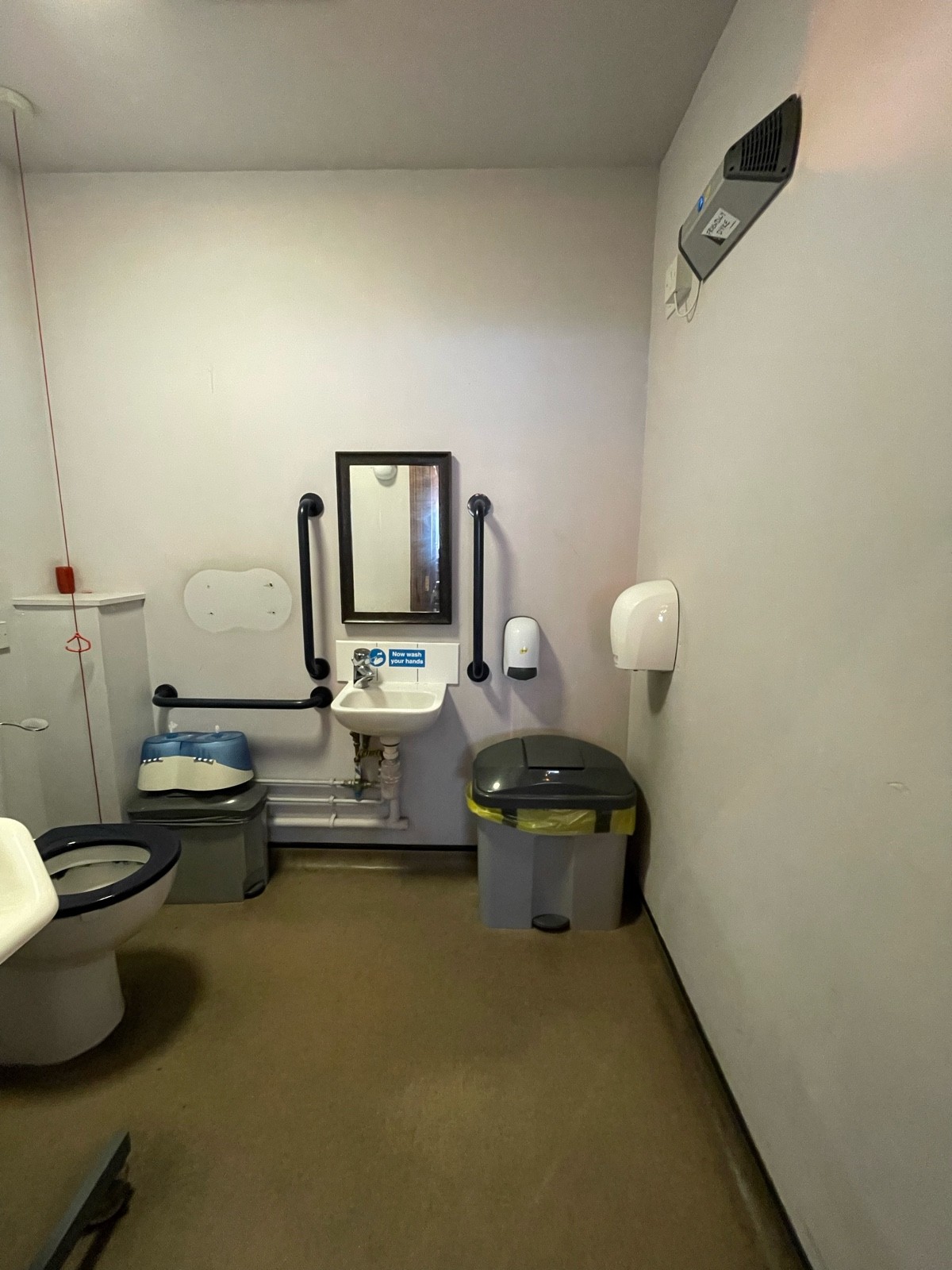 From door, facing straight. Sink at back. Toilet on left.
