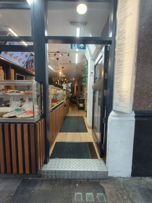Facing single black-framed glass door. Push silver metal handles on left to open.