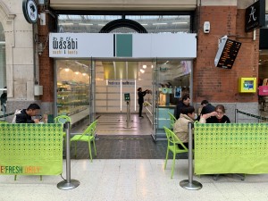 From inside station facing venue. Fence to left and right, seating behind. Path centre to entrance.