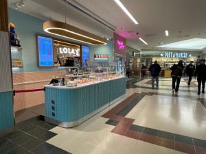 From first floor inside shopping center facing venue. Sales counter ahead. No doors.