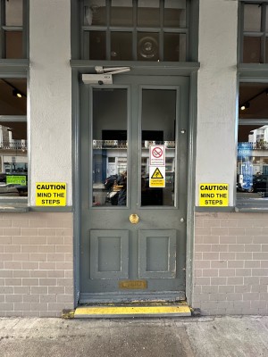 Grey and glass panelled door. Gold knob in centre, push to open.