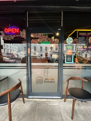 Glass doors with grey frame. Silver vertical handle on left, push to open.