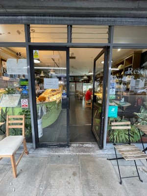 Double glass doors with black frame ahead. Black metal square handles to centre. Push to open.