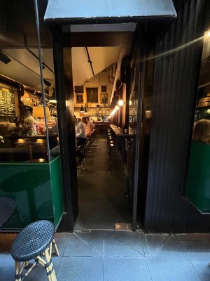 Glass door with black metal frame. Push from left.