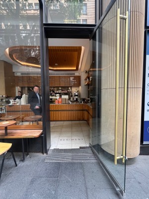 Glass door with grey metal frame. Pull from left.