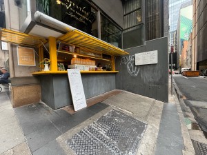 No entrance leading to kiosk service counter. Path slightly sloped upwards leading to counter.