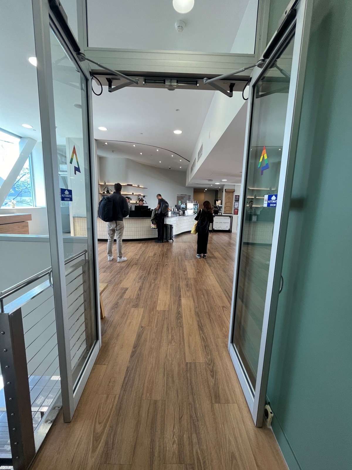 From top of steps facing left. Glass double doors with metal frame ahead. Doors open automatically.