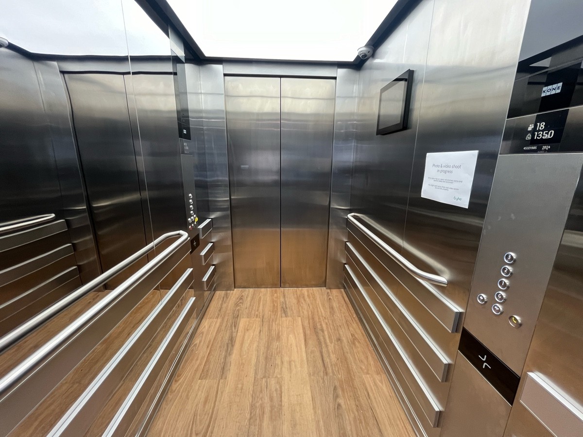 From lift doors facing straight. Grab rails and control panels on either wall.